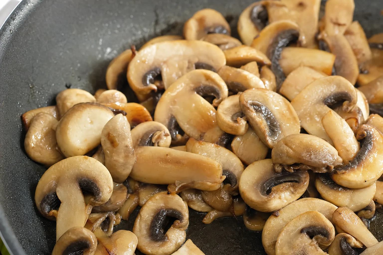 Gros plan de champignons de Paris tranchés cuits nature dans une poêle